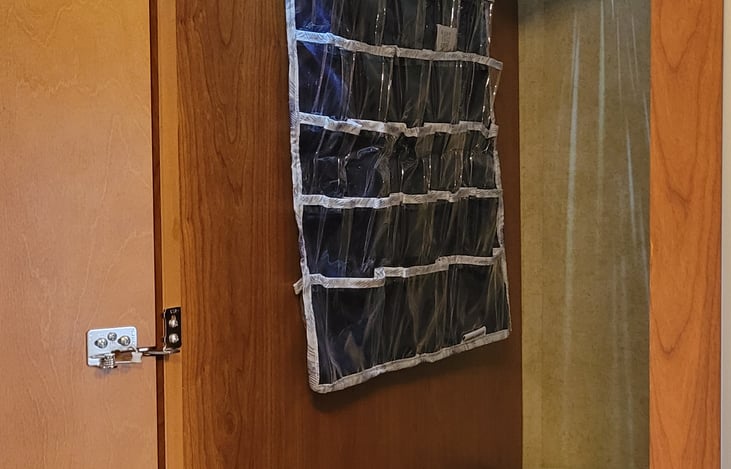 Large closet with hangers, two plastic tote and shoe tray.