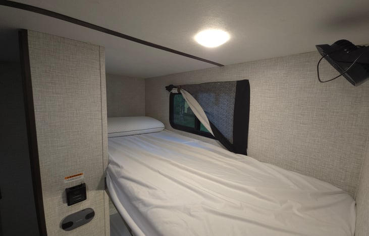 Top bunk with lighting, USB charging, and a fan