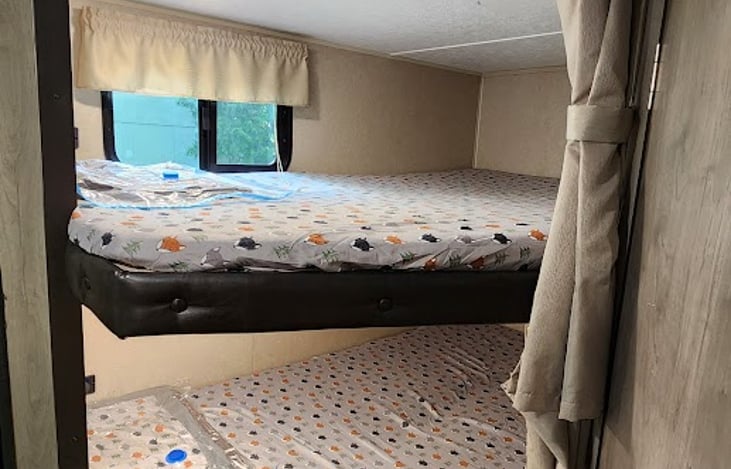 Lower/upper double bunks with USB power outlets, accessible with ladder stored in front of the camper