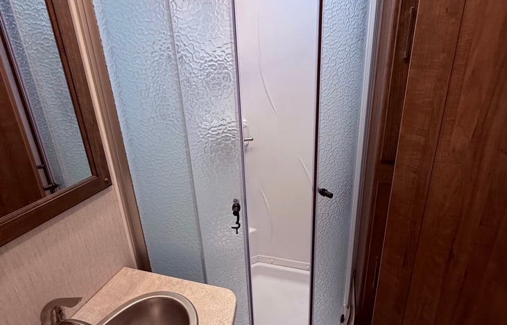 Enclosed standing shower in full privacy bathroom.