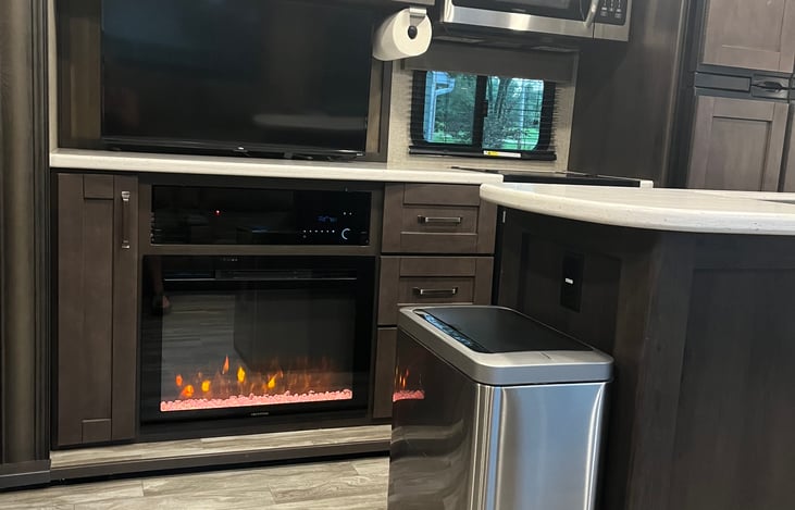 Large smart TV on a swivel mount and an electric fireplace that does heat the RV, and the DVD/Stereo are located under the TV.