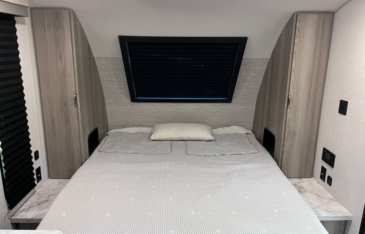 Queen Bed with storage closets on each side.