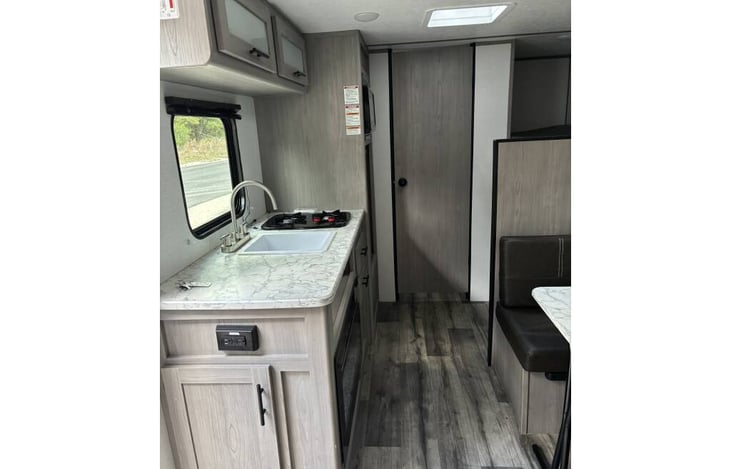 kitchen, table space (that makes into a bed) bunk beds on back right and bathroom behind the door