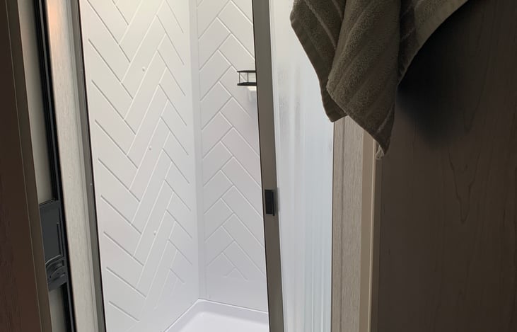 Easy in and out shower with hand wand. There is also an access door in the bathroom.