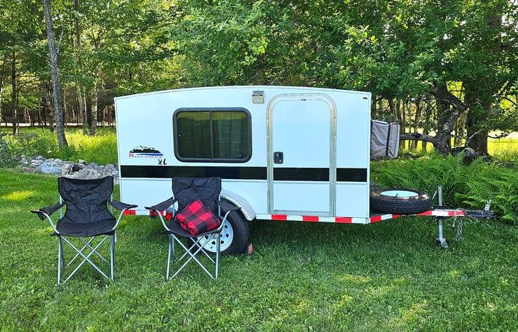 Exterior Right Side - Keyed Entry Door, Solar Light, Locking Windows (one on each side with curtains and screens)