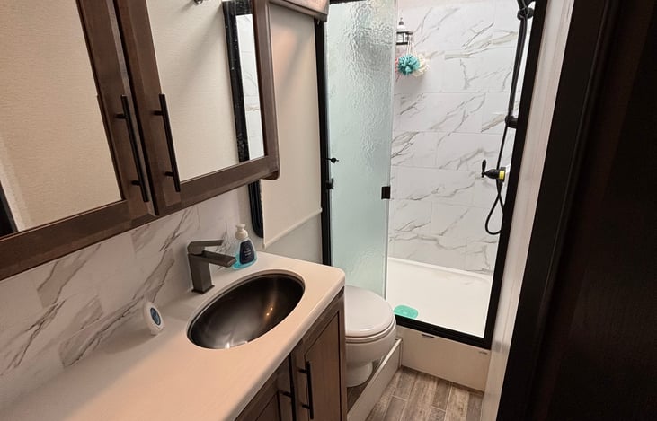 Full bathroom with tall walk-in shower with a skylight