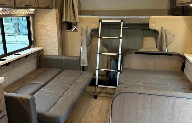 Couch and dinette converted into beds. Privacy curtain for upper loft and dash.