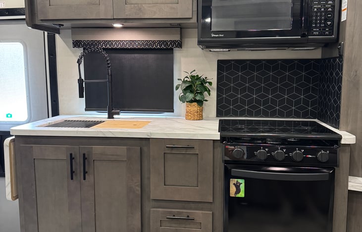 Kitchen with Microwave, gas Stove and Oven.