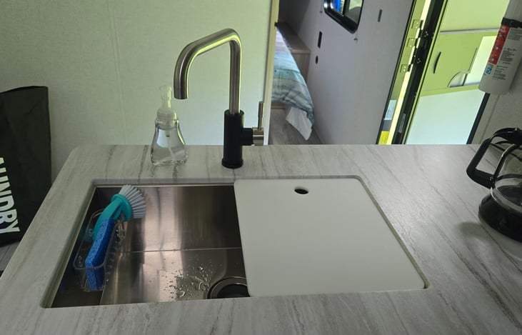 Hand soap, sponge, scrub brush, dish rack and mat for drying