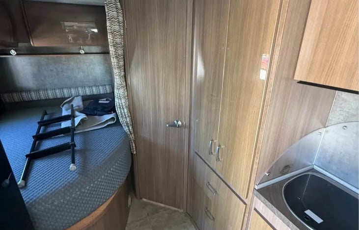 bed in back with storage underneath and more storage all around