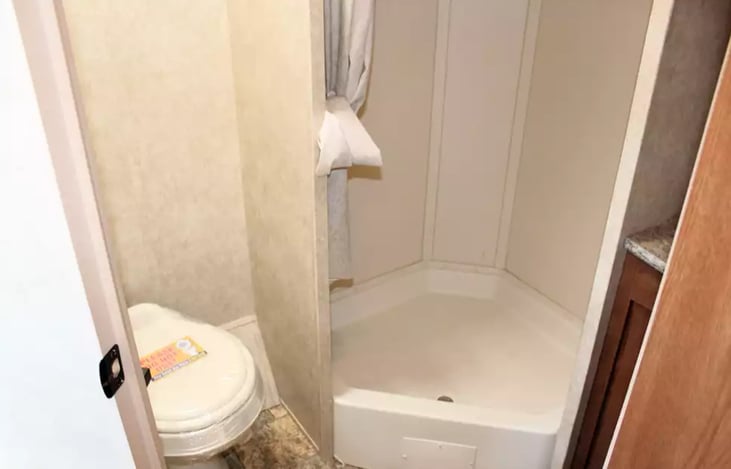 Bathroom with toilet, shower, and sick.