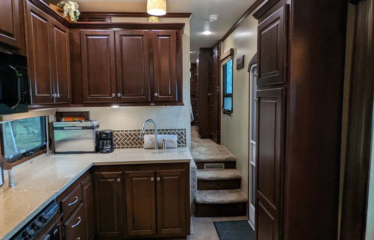 View of fully equipped kitchen and hallway to bathroom and Master bedroom from living room.