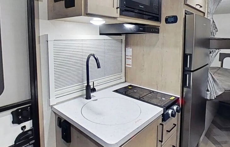 Fully stocked kitchen with a fully fridge, dedicated freezer, microwave, and sink