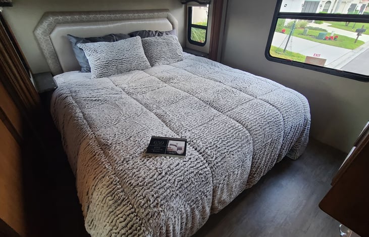 King size master bed with luxury sheets.