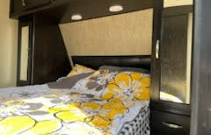 Master bedroom bed showing mirror storage on other end.