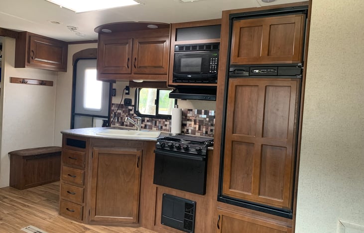 Kitchen with 3 burner range, oven, sink with cover for extra counter space
Includes a single serve Keurig coffee maker