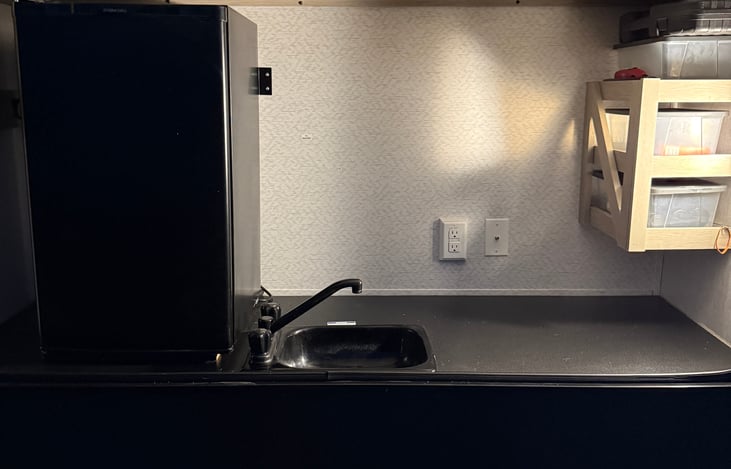 Outdoor kitchen. Sink, refrigerator, and storage with cooking utensils for the grill.