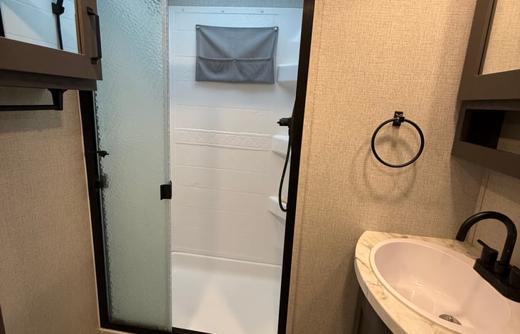Glass door shower and two cabinets.