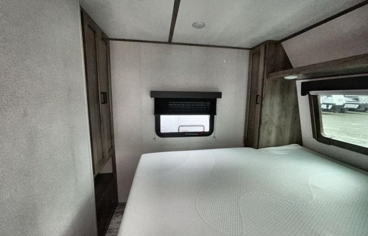 Private master suite featuring a king-size bed with under-bed storage, overhead cabinets, and a closet for all your essentials.