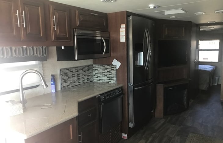 Spacious Kitchen with microwave, oven, stovetop, fridge,  double sink, fully stocked kitchen ( plates, cups, cutlery, instapot, toaster, coffee maker, pots, pans, etc.)