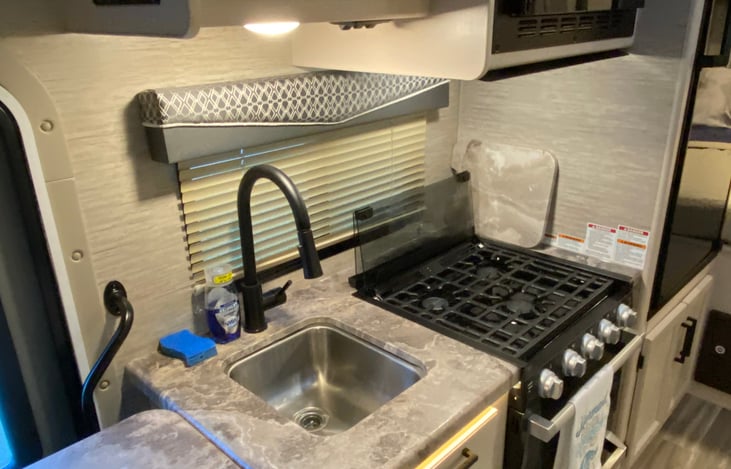 Kitchenette sink, range and oven.