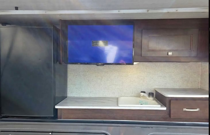 Outdoor Kitchen: Convenient exterior kitchen featuring a refrigerator, sink, storage cabinets, countertop space, and TV—perfect for keeping drinks cold, preparing snacks, and enjoying outdoor entertai