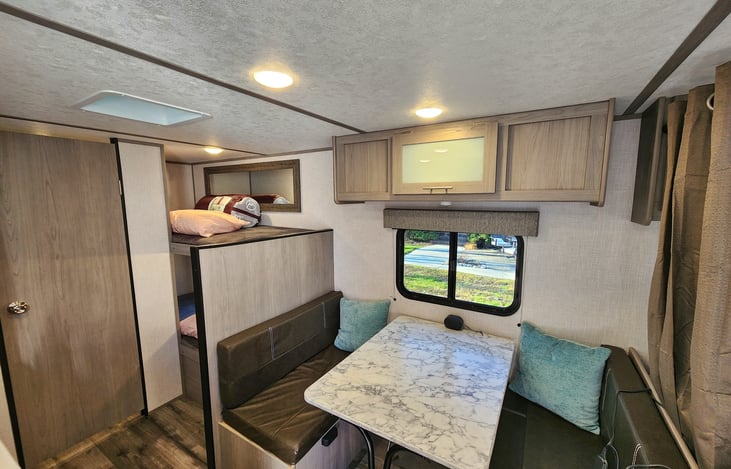 Dinette table folds down for additional sleeping area or can be used outside.