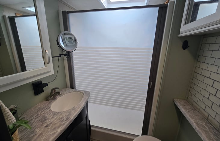 Bathroom with upgraded retractable shower enclosure
