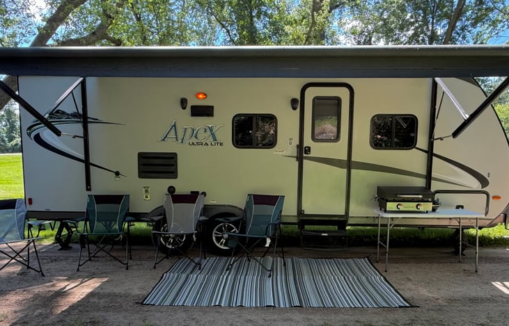 This is a well-maintained Apex Ultra Lite travel trailer with a powered awning. Four camp chairs will be included.