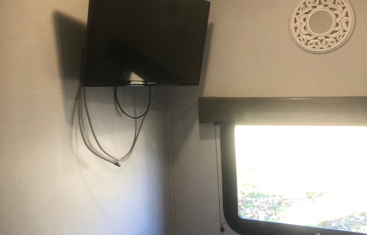 TV hanging on wall in Master bedroom next to the emergency exit windown