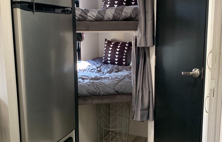 Two bunk beds sleep two children in each or one adult comfortably. Each bed has its own curtain for privacy and a window.