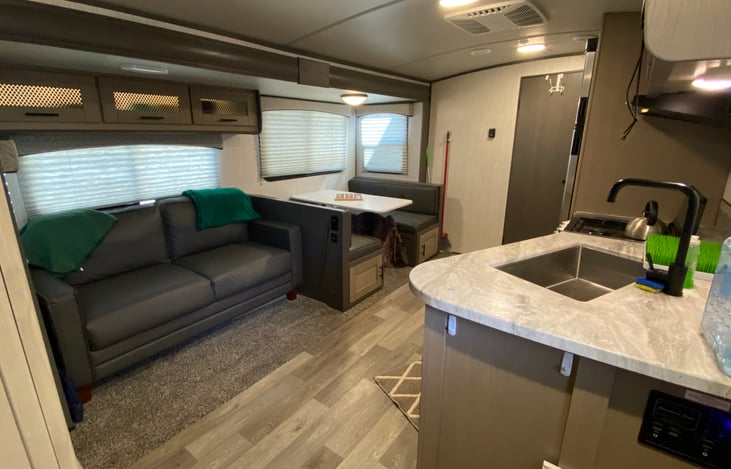 A full shot of the living room, kitchen and eating area all in one. The kitchen table has the ability to fold down to sleep a few more. *We've used it for the pack and play. Safe but out of the way.