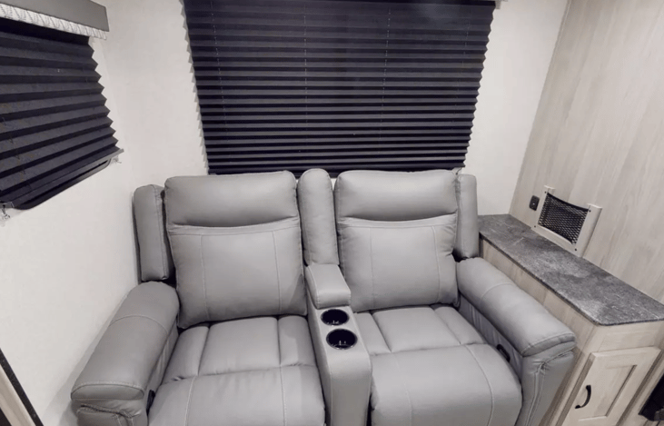 Enjoy theater seating recliners in the slide out space with included cupholders!