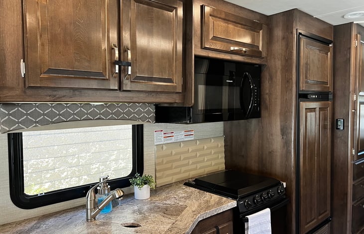 Kitchen with ample storage. Microwave, stove and oven. Double rimmed sink with covers. Extendable faucet for easy washing.