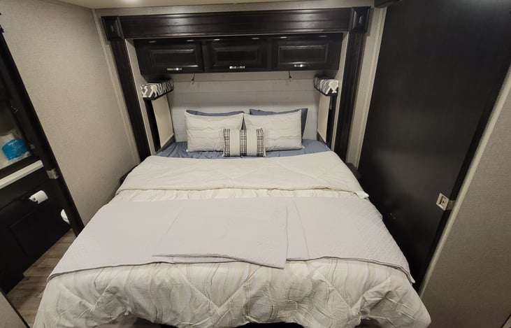 Master bed with foam padded mattress and linens.