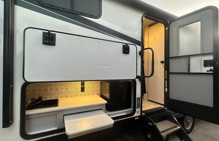 Outdoor kitchen with mini fridge, sink and prep table