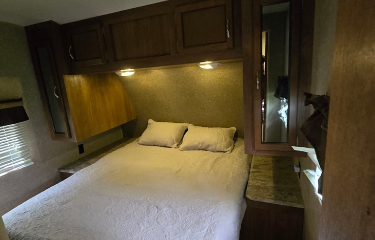 Queen bed with new memory foam mattress topper and bedding.