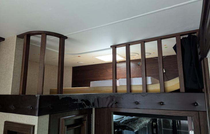 A loft above the kitchen area with a ladder, fits one person.