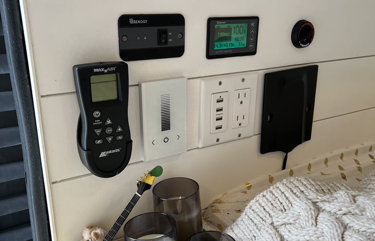 Remote for Maxx Air fan. Inverter switch. Solar charge panel. Webasto heater switch. Sliding dimmer. The last black square is a wifi antennae. 4 USB plugs, 2