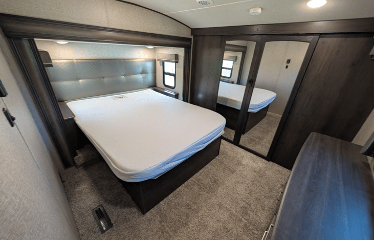 Private master suite with a queen bed, residential mattress, reading lights, deep dresser drawers, massive front wardrobe with hanging space, and washer/dryer prep. High-end restful comfort!