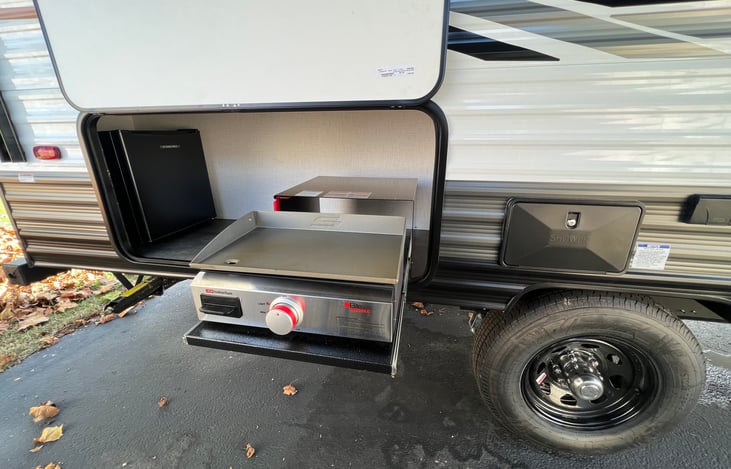 Outdoor kitchen with small fridge and griddle (and outdoor shower)