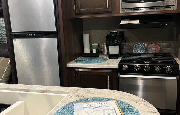 Kitchen has a 3 burner gas stove and oven; pots and pans