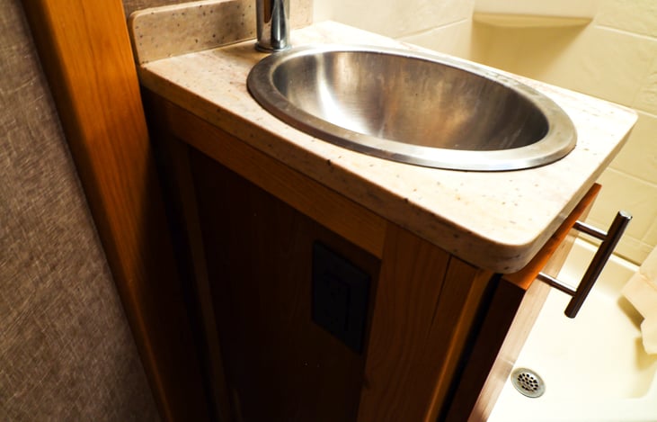 Bathroom sink with shower behind it