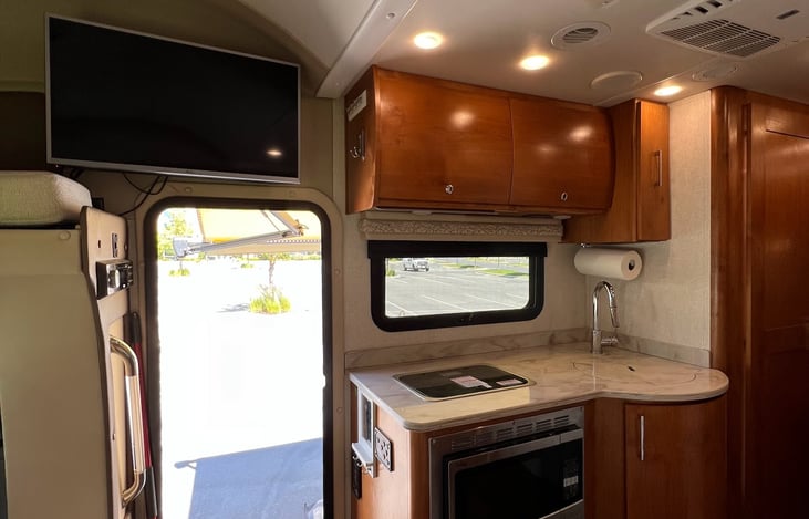 Plenty of cabinet space and a television in the kitchen area.