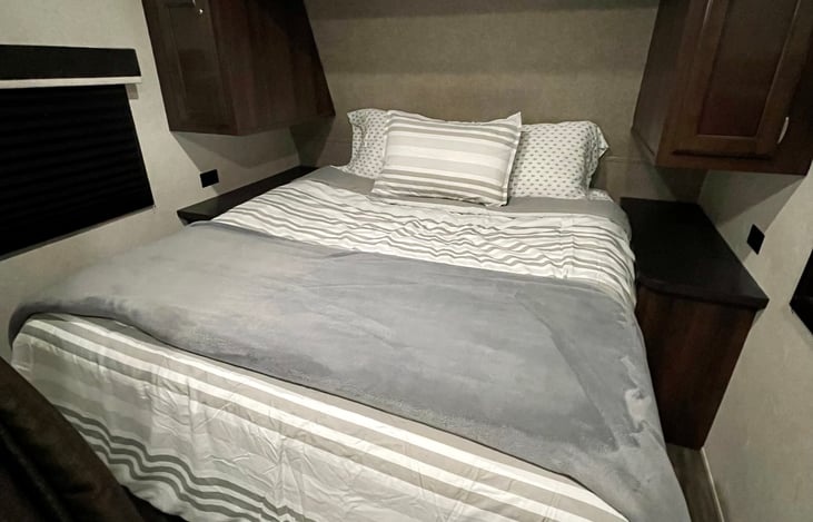 Walk-around queen bed with storage access underneath. Hanging closet and shelved closet.