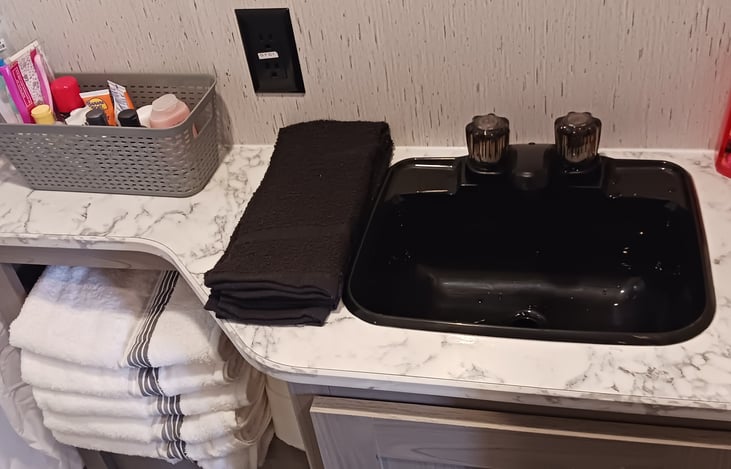 The bathroom sink and some complimentary toiletries