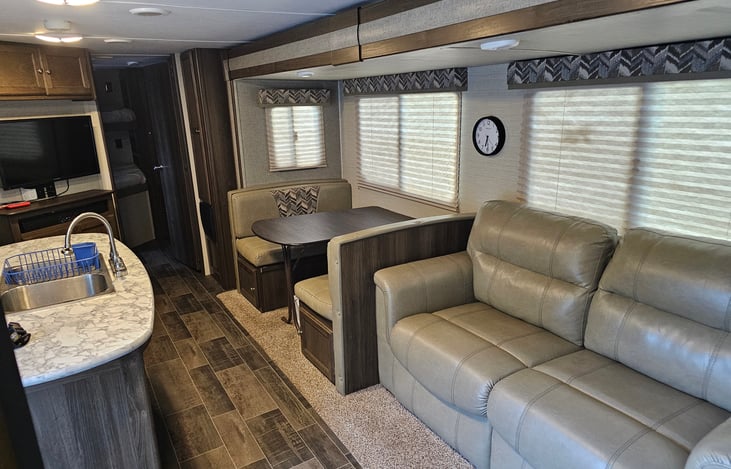Extra large living area with two slide-outs and an island sink. TV with Roku device. Indoor and outdoor Bluetooth soundbar. Fold out couch and convertible sleeper dinette.