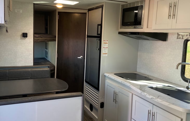 Kitchen includes sink, fridge, stove top and microwave