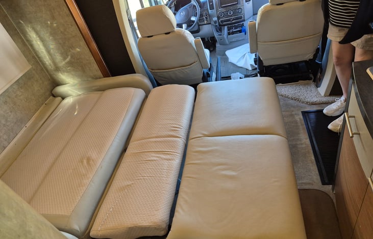 The sofabed is in the common area and opens with the slide out. There is a curtain in the cubby above the fridge that hangs between the sleeping areas.