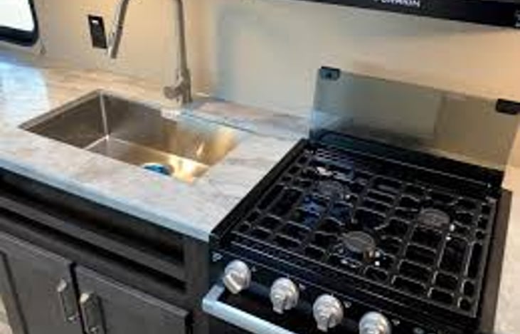 Stove and oven and sink area.